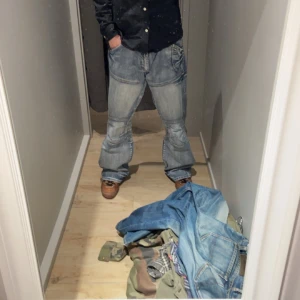 Blå jeans från Fishbone - Säljer ett par unika blå jeans från Fishbone med en loose/ bootcut passform. Byxorna köptes från vintage and friends för en månad sedan och har ej avändts pga vädret. Mycket hög kvalitet på jeansen med en väldigt detaljerad design. Storlek 34/34