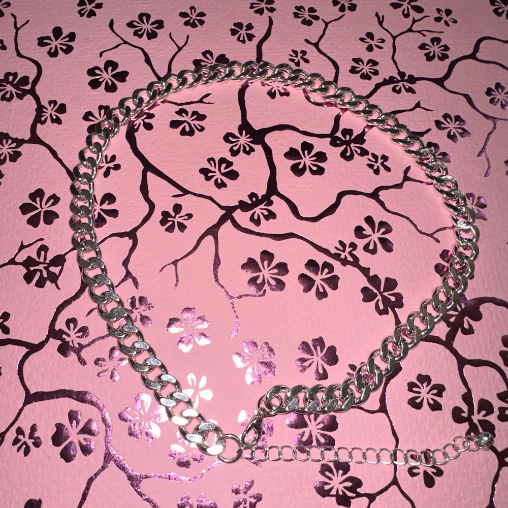 Snyggt och stilrent silverfärgat halsband med breda länkar. Perfekt för att ge en extra touch till din outfit. Justerbar längd för bästa passform.. Asusteet.