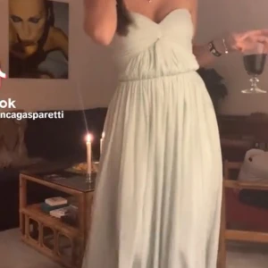 Ljusgrön balklänning - Elegant ljusgrön axelbandslös långklänning med draperad överdel och knytning framtill. Perfekt för en somrig fest eller bal. Köpt på Vinted, har själv aldrig anvönt klänningen men förra ägare använde den en gång 