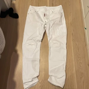Vita jeans från Dsquared2 - Snygga vita jeans från Dsquared2 med tryck på baksidan. De har en klassisk femficksdesign och knappar i midjan. Perfekta för en stilren look.