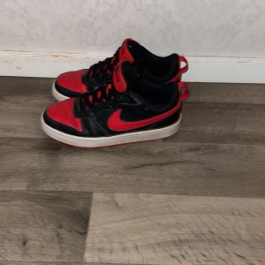 Nike sneakers i svart och rött jätte snygga nya bara använd några gånger  - Snygga Nike sneakers i svart och rött med klassisk design. Skorna har snörning och en vit sula som kontrasterar mot det färgglada mönstret. Perfekta för en sportig look.