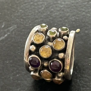 Silverring 925 Multistone Ring from India | Garnet Peridot Topaz Amethyst Ring - Unik silverring med flera infattade stenar i olika färger, inklusive lila och gul. Ringen har en robust design med en bred band och är stämplad med 925 för silverkvalitet.