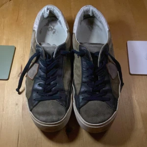 Beige Philipe models med mörk blå/ svarta detaljer - Säljer ett par beige sneakers med svarta / mörkblå snörningsdetaljer.  Pris går att diskuteras.                  Ny pris 2500