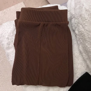 Bruna ribbade leggings från DF Young - Snygga bruna leggings från DF Young i storlek XS. De är ribbade och har en tight passform, perfekta för en stilren look. Passar bra till både vardag och avslappnade tillfällen.