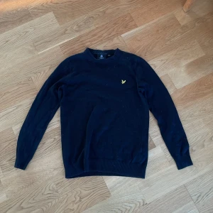 Finatickad tröja från  Lyle & Scott - Säljer en stilren svart tröja från Lyle & Scott med deras ikoniska gula logotyp på bröstet. Tröjan har långa ärmar och är perfekt för en avslappnad look. Passar bra till både jeans och chinos!