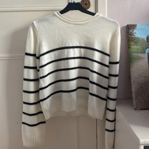 Vit och svart randig tröja från H&M - Säljer en stilren vit tröja med svarta ränder från H&M. Tröjan är stickad och har långa ärmar med ribbade muddar. Perfekt för en avslappnad look. Endast använd fåtal gånger, inga defekter eller slitningar. Den har inga noppror. Nyskick! Den är i storlek 158-164 men passar mig som brukar ha xs/xxs💗