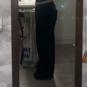 Svarta mjukisbyxor från Juicy Couture - Snygga svarta mjukisbyxor från Juicy Couture med hög midja och en loose passform. Byxorna har praktiska fickor med knappar och snörning i midjan för extra komfort. Perfekta för en avslappnad stil.  Jag är 170 ich och dom är lite långa, sann till storleken. Betalning sker via swish, mer info kan man adda min snap:nova.202 eller skriva här på plick☺️