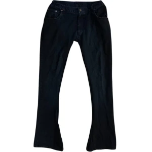 Mörkblå bootcut jeans - Snygga Mörkblå bootcut jeans med klassisk femficksdesign och knappgylf. Perfekta för en stilren look. Mått: Midja 38cm, Längd 110cm, benöppning 23 cm.