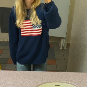 Mörkblå stickad tröja - Mörkblå stickad tröja med amerikanska flaggan på. Köpt på Hollister i USA för ca 600 kr. Använd max 5 gånger och i mycket fint skick, inte nopprig alls eller så. Strl S men oversized. 