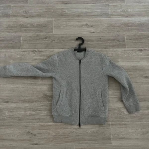 Grå cardigan  - Snygg grå quiltad cardigan med dragkedja från j.Lindeberg 