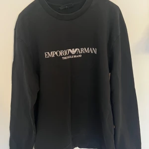 Svart tröja från Emporio Armani - Säljer en svart tröja från Emporio Armani med deras logga tryckt på bröstet. 