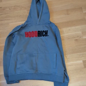  hoodrich tröja - Säljer en hoodrich tröja storlek 12-13år L. tröjan från jd med stor ficka framtill och texten 'HOODRICH' i rött och svart på bröstet. Tillverkad i 80% bomull och 20% polyester, perfekt för en avslappnad stil.