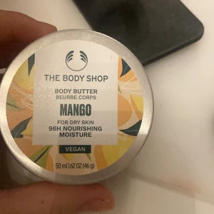 Mango Body Butter från The Body Shop - Härlig mango body butter från The Body Shop, perfekt för torr hud. Ger 96 timmars närande fukt och är vegansk. Kommer i en burk på 50 ml.