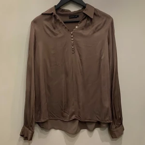Brun blus med krage  - Brun blus med krage. Knappar fram och i ärmslut.              Kolla gärna min profil, säljer mycket nu, allt i fint skick och till bra pris