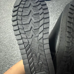 Svarta UGZ med pälsfoder inuti - Säljer ett par svarta UGZ med mjukt pälsfoder och robust sula. Perfekta för kalla dagar med sin varma insida och stilrena design. Märket UGZ syns på baksidan av skorna. Storlek 37 passar bra för 36 och mer inte använd fick det som en present den var för lite inte fri frakt frakten betalar ni skyddar mot vatten vatten kommer inte in strumporna blir ej blöta när de regnar eller snöar helt ny 