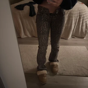 Leopard bootcut jeans från Nelly - Snygga bootcut jeans från Nelly med ett unikt leopardmönster. Byxorna har låg midja och är perfekta för att ge en trendig touch till din outfit. De är tillverkade i ett bekvämt material som ger en bra passform. Säljer dessa eller byter mot ett par nya i 34