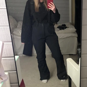 Svarta Skidbyxor - Säljer svarta skidbyxor/täckbyxor från lager 157. Super sköna och sitter snyggt. Jag är 160 cm och dom är rätt långa på mig. Köpta förra året. Storlek M. Med hängslen.