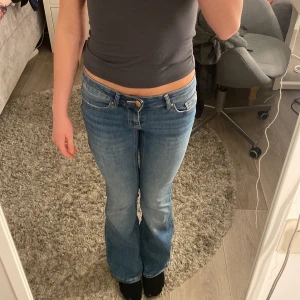 Blå bootcut jeans - Snygga blå bootcut jeans med låg midja och klassisk femficksdesign. Perfekta för en avslappnad stil. Från vero Moda lågmidjade 