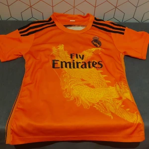 Orange fotbollströja  - Säljer en cool orange fotbollströja från Adidas med korta ärmar. Tröjan är S men är som typ xxs. Skick 7/10.  Kommer med shorts