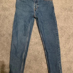 Blå jeans från Weekday - Snygga blå jeans från Weekday i modellen Barrel Relaxed Tapered. De har en klassisk femficksdesign och är tillverkade i denim. Perfekta för en avslappnad stil. Är i storleken 29/32.