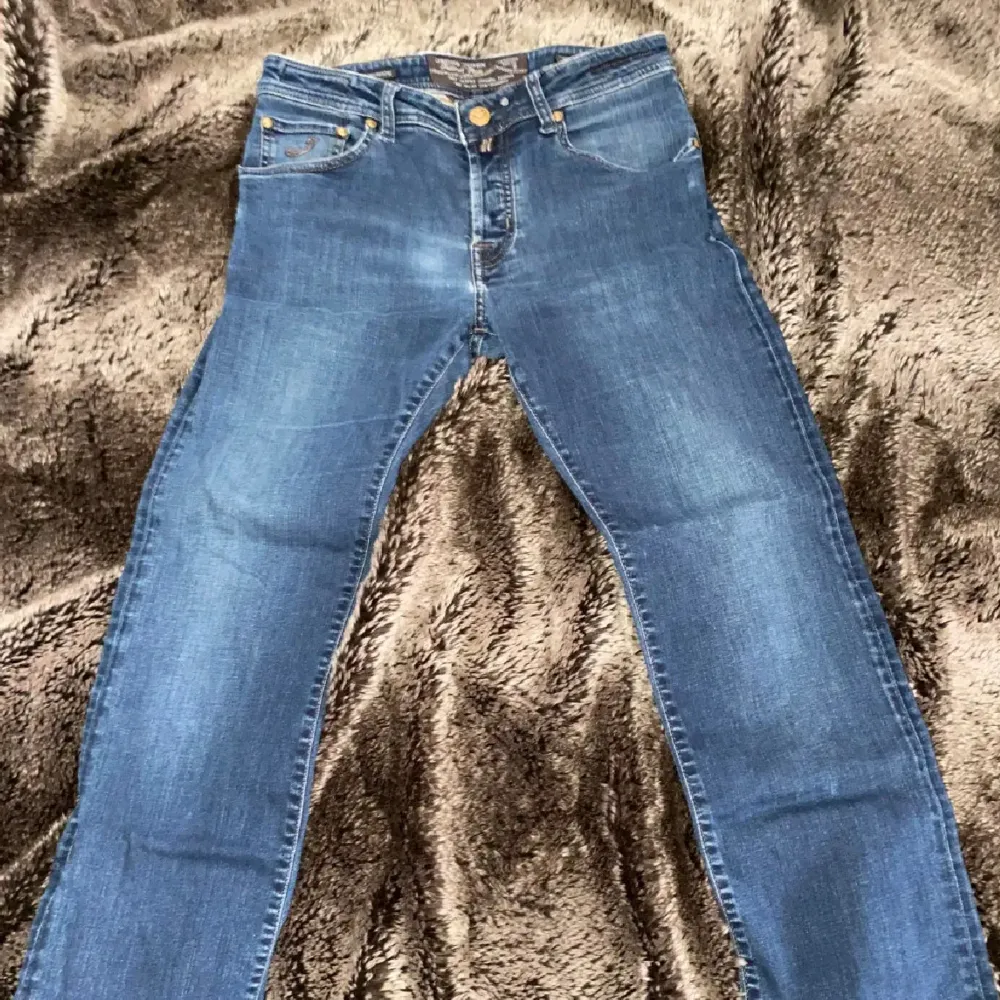 Snygga blå jeansbyxor från Jacob Cohen med knappgylf och klassisk femficksdesign. Byxorna har en straight passform och är perfekta för en avslappnad stil. Märket '620 Special' syns på insidan av gylfen. Storlek 32/32 passar perfekt om du är mellan 180-185.. Farkut & Housut.