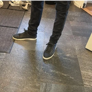 Svarta sneakers från Burberry - Snygga svarta sneakers från Burberry med klassiskt rutigt mönster. Skorna har snörning och en vit sula som ger en stilren look. 