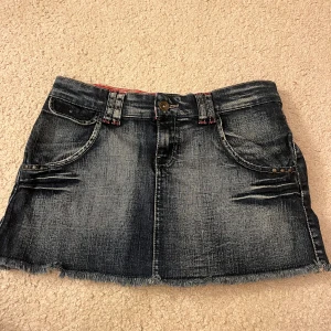 Jeanskjol från stradivarius - Snygg jeanskjol från Stradivarius med slitna detaljer och fransig nederkant. Kjolen har två fickor framtill och en plisserad baksida för en unik look. Midjemått: 38cm rakt över. Längd: 30 cm. Använd gärna köp nu 💕💕