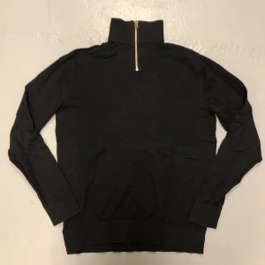 Svart tröja med dragkedja från Jack & Jones - Säljer en stilren svart tröja från Jack & Jones i storlek S. Tröjan har en praktisk dragkedja vid halsen och är tillverkad i ett mjukt material. Perfekt för billigt men om man ändå vill se fin o ha stil 