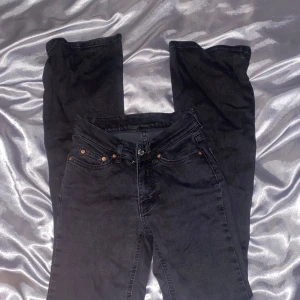 Svarta jeans från Gina Tricot - Snygga svarta jeans från Gina Tricot med klassisk femficksdesign och knappgylf. Perfekta för en stilren look. De har en normal passform och är tillverkade i ett slitstarkt material. Lågmidjade 