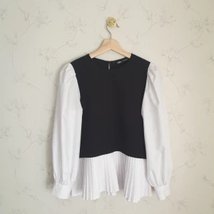 Zara vit blus svart slipover - 🧁FÖRST TILL KVARN!🧁 Klassisk och elegant vit blus med en fastsydd svart väst. På ytter kanten av blusen är den plisserad. Superfin men inte buren så ofta av mig därför säljer jag vidare den. Vill bli av med ASAP!❣️