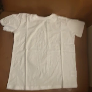 Vit t-shirt - En klassisk vit t-shirt med korta ärmar. Perfekt basplagg för alla tillfällen. Enkel och stilren design.