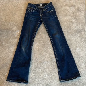 Mörkblå bootcut jeans från Gina Tricot - Snygga mörkblå bootcut jeans från Gina Tricot med kontrastsömmar. Klassisk femficksdesign och knappstängning. Perfekta för en avslappnad stil. Säljer de för att de är försmå!