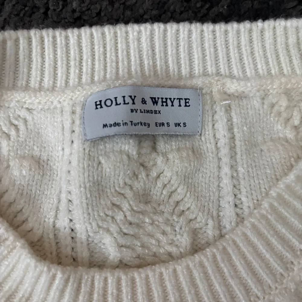 Säljer en vit stickad tröja från Holly & Whyte by Lindex. Tröjan har ett flätmönster och volangdetaljer. Helt ny och aldrig använd. Kan diskutera pris.. Neuletakit & Villapaidat.
