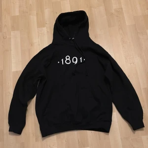 Svart hoodie från AIK - Säljer en svart hoodie från AIK med trycket '1891' på framsidan. Tröjan har en klassisk design med huva och känguruficka. Perfekt för alla AIK-fans! 🖤
