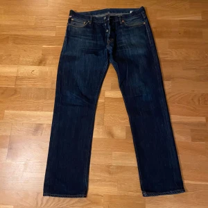 Mörkblå jeans från Ralph Lauren - Snygga mörkblå jeans från Ralph Lauren med klassisk femficksdesign och knappgylf. Jeansen har en rak passform och är tillverkade i slitstarkt denim. Perfekta för en stilren look.