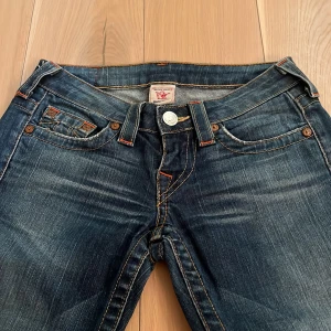 Mörkblå jeans True Religion  - Jättesnygga detaljerade g-rise blå jeans från True Religion  💕dessa jeansen är vintage och finns inte att köpa längre ❣️