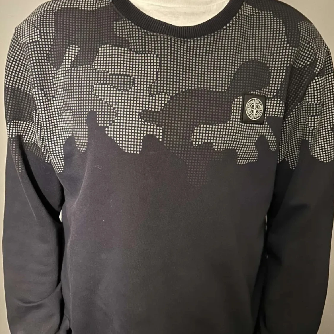 Svart tröja med kamouflagemönster från Stone Island