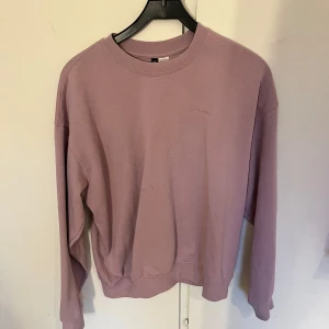 Lila sweatshirt  - Säljer en stilren lila sweatshirt. Tröjan har en klassisk rund hals och långa ärmar. Perfekt för en avslappnad look. Passar bra till både jeans och joggers.