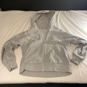 Grå hoodie från Lindex - Tjoo, Säljer en grå hoodie från Lindex i storlek 146/152. Den har en dragkedja framtill och en mysig huva. Perfekt för kyliga dagar och passar bra till vardagsoutfiten. Jag säljer den på grund av att den är för liten.