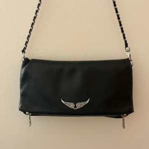 Svart axelväska med kedjedetaljer - Säljer min Zadig&Voltaire väska pågrund av att den inte används längre. Väskan är i väldigt fint skick. Köpte den ny för 3600kr💕pris kan diskuteras💕