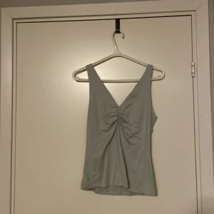 Vit Linne - Benvit topp med lite scrunch framtill. Väldigt strechig kan passa s,m och l.