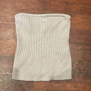 Grå ribbad tubtopp från Abercrombie & Fitch - Säljer en snygg grå ribbad tubtopp från Abercrombie & Fitch i storlek XS. Toppen är oanvänd och är stretchiga. Passar både till vardags och fest!