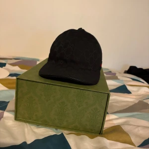 Svart gucci keps - Säljer nu min gucci keps då jag knappt använder den. Kepsen har varit i god förvaring och använt på ett bra sätt utan några skador alls. Kepsen är 100% äkta ingen ide att komma med att den inte är det då jag har box dustab och kvitto. Kepsarna ligger just nu på runt 6000kr ny pris.