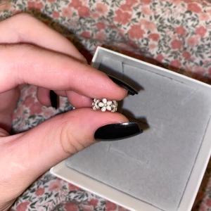 Silver berlock med tusenskönor  - Säljer en söt berlock med små blommor runt om. Tusenskönor, från Pandora. Nypris: 349kr