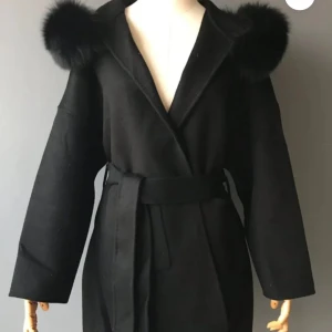 Svart kappa med päls  - Säljer min fina kappa, den har inte kommit till användning som jag hade tänk så vill sälja den nu! Den är i jätte fint skick inga konstigheter! Skriv gärna till mig om du vill ha privata bilder på kappan eller andra frågor! Fler som skriver så försök gärna buda om ni kan! Men kommer inte ta mer betalt än 1200 som max💞💞
