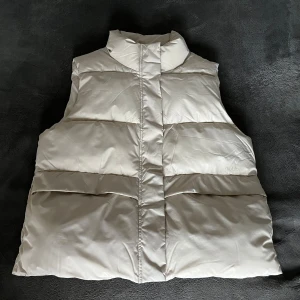 Beige väst från Dobber - Säljer en oanvänd beige dam väst från Dobber i storlek S! Denna helt nya väst är både varm och perfekt för hösten. Nypris 1000kr.  Västen är även behandlat med Bionic-Finish Eco, en vattenavstötande impregnering.
