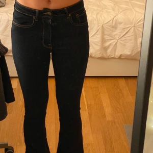 Mörkblå midwaist bootcut jeans -  Från Zara i st 34 med fina kontrasterande sömmar i bronsaktig färg. I mycket bra skick då de knappt är använda. 
