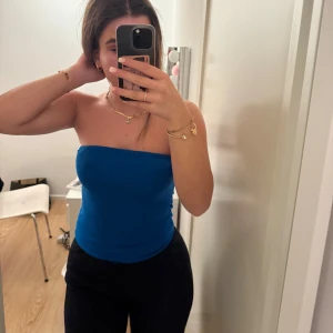 Blå tubtopp från NAKD - Snygg blå tubtopp i tight passform, perfekt för sommardagar eller en utekväll. Toppen är ärmlös och ger en stilren look. Matcha med jeans eller kjol för en komplett outfit! 