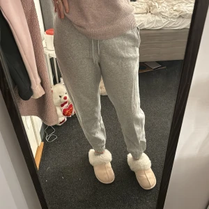 Grå mjukisbyxor från Pigalle - Superbekväma grå mjukisbyxor från Pigalle i storlek S. Perfekta för mysiga dagar hemma eller en avslappnad dag ute. De har en elastisk midja och muddar vid bensluten för extra komfort. Passar perfekt till en hoodie eller en mysig tröja. 🩶