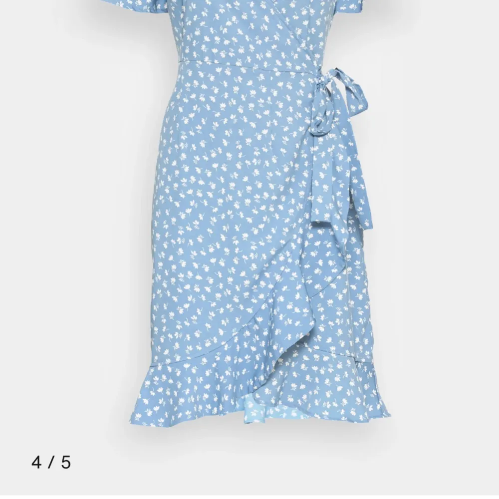 Säljer en superfin blommig omlottklänning från ONLY. Den har en v-ringad design med korta ärmar och ett färgglatt blommönster i lila, orange och vitt på en svart bakgrund. Perfekt för vår och sommar! 🌸endast använd ett fåtal gånger. Obs! Inte samma färg som på första bilden men jag tror att modellen är samma!💞. Mekot.